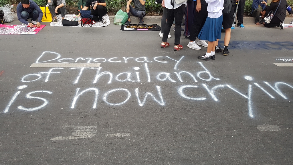 헌재 판결을 비판하며 누군가 도로 위에 적은 '태국 민주주의가 울고 있다'는 문구