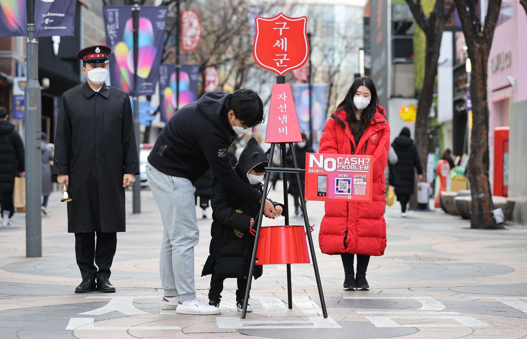 서울 중구 명동 거리에서 한 어린이가 구세군 자선냄비에 성금을 넣고 있다. [연합뉴스 자료사진]
