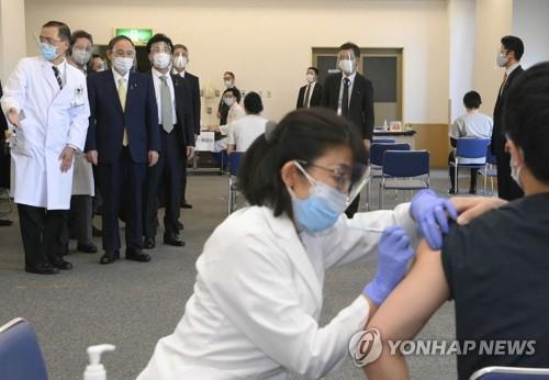 스가 요시히데(위 왼쪽 2번째) 일본 총리가 지난 18일 도쿄메디컬센터에서 코로나19 백신 접종 모습을 지켜보고 있다. [AFP=연합뉴스 자료사진]