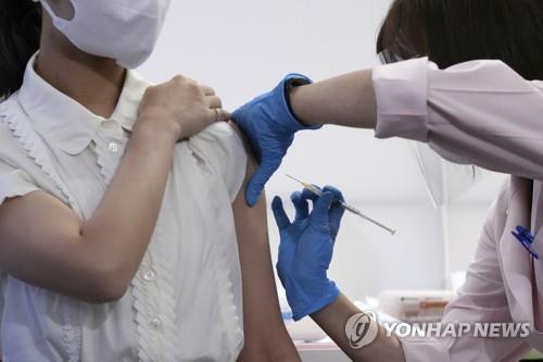(도쿄 AP=연합뉴스) 도쿄 하네다공항의 일본항공(JAL) 의료실에서 지난 14일 객실 승무원이 코로나19 백신을 맞고 있다. 