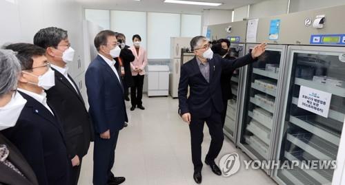 El presidente surcoreano, Moon Jae-in (cuarto por la izda.), escucha las explicaciones sobre la forma de almacenar las vacunas contra el nuevo coronavirus de AstraZeneca, el 26 de febrero de 2021, durante una visita a un centro de salud pública en Seúl, cuando el país dio inicio al programa nacional de inoculaciones, a las 9:00 a.m. Más de 5.000 trabajadores médicos y pacientes menores de 65 años de edad, en alrededor de 5.800 centros de cuidados prolongados, fueron los primeros en ser inoculados.
