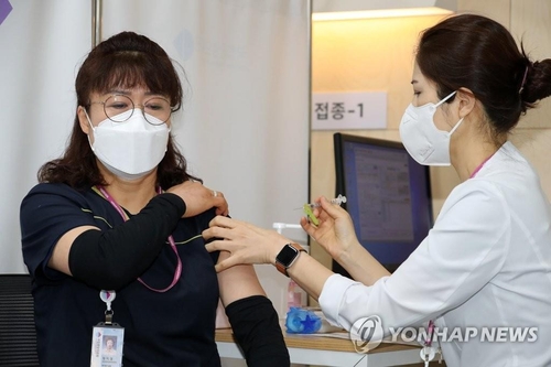 Una trabajadora sanitaria en el Centro Médico Nacional, situado en el centro de Seúl, recibe la primera inyección de las vacunas contra el coronavirus de la farmacéutica Pfizer, el 27 de febrero de 2021.
