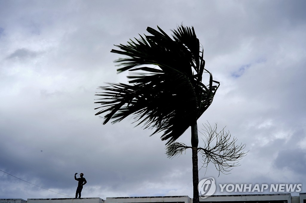 1일(현지시간) 초강력 허리케인 도리안 상륙을 앞두고 그랜드 바하마에서 한 남성이 태풍에 대비해 건물 옥상을 점검하고 있다.[AP=연합뉴스] 