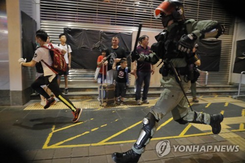 경찰이 지난 13일 시위 참가자를 쫓고 있다.