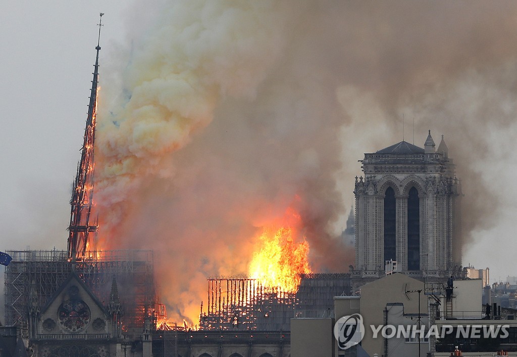 작년 4월 15일 화재 당시 파리 노트르담 대성당의 첨탑(왼쪽)이 불길을 이기지 못하고 무너져내리고 있다. [AP=연합뉴스 자료사진] 