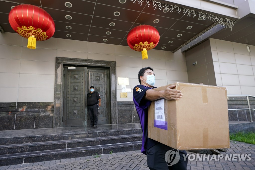 This AP photo, taken on July 23, 2020, show a FedEx worker removing a box from the Chinese Consulate in Houston, Texas, one day after the U.S. ordered the Chinese consulate to be shut down, citing what it called "espionage" activities by Chinese diplomats there. (PHOTO NOT FOR SALE) (Yonhap)