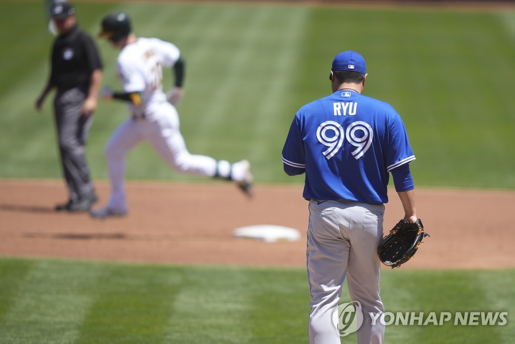 In this Associated Press photo, Ryu Hyun-jin of the Toronto Blue Jays (R) stands on the mound as Mark Canha of the Oakland Athletics (C) rounds the bases following a solo home run during the bottom of the first inning of a Major League Baseball regular season game at Oakland Coliseum in Oakland on May 6, 2021. (Yonhap)