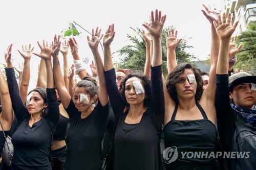 경찰의 과잉 진압에 항의하기 위해 검은 옷을 입고 한쪽 눈을 가린 시위대