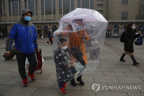 지난 11일 베이징 철도역서 비닐과 마스크로 무장한 가족