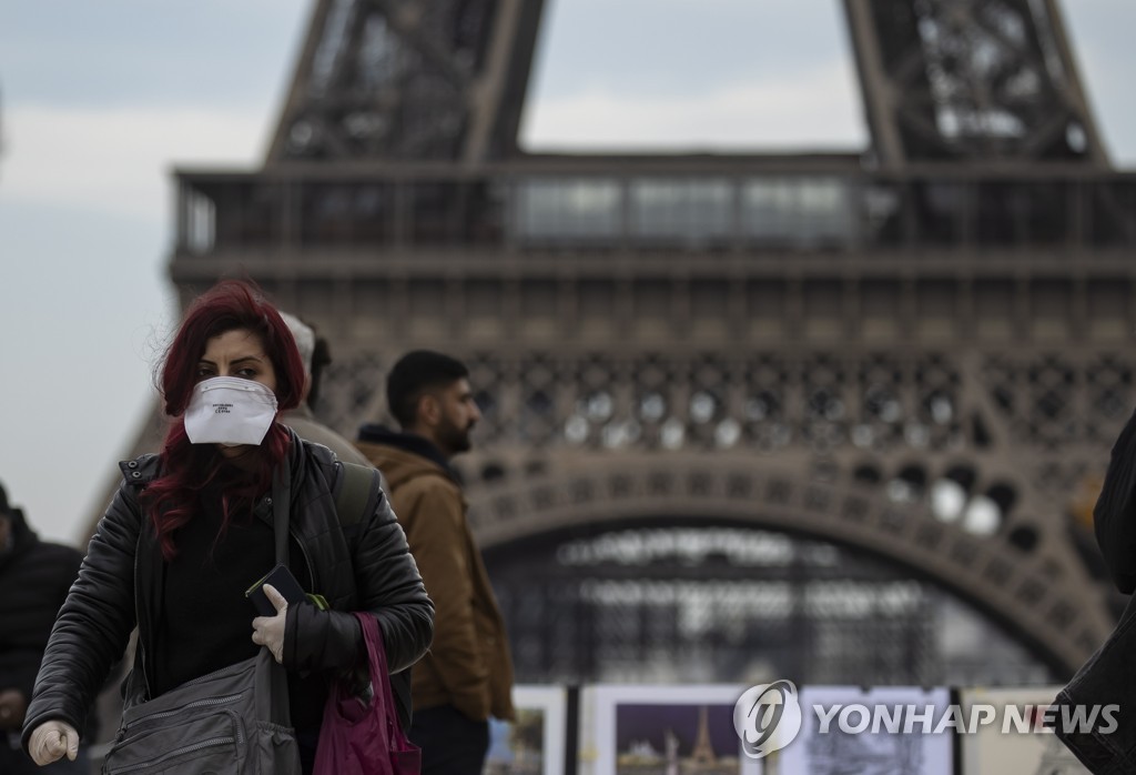 지난 15일 프랑스 파리 에펠탑 인근에서 한 행인이 마스크를 쓴 채 걸어가고 있다. [EPA=연합뉴스 자료사진]