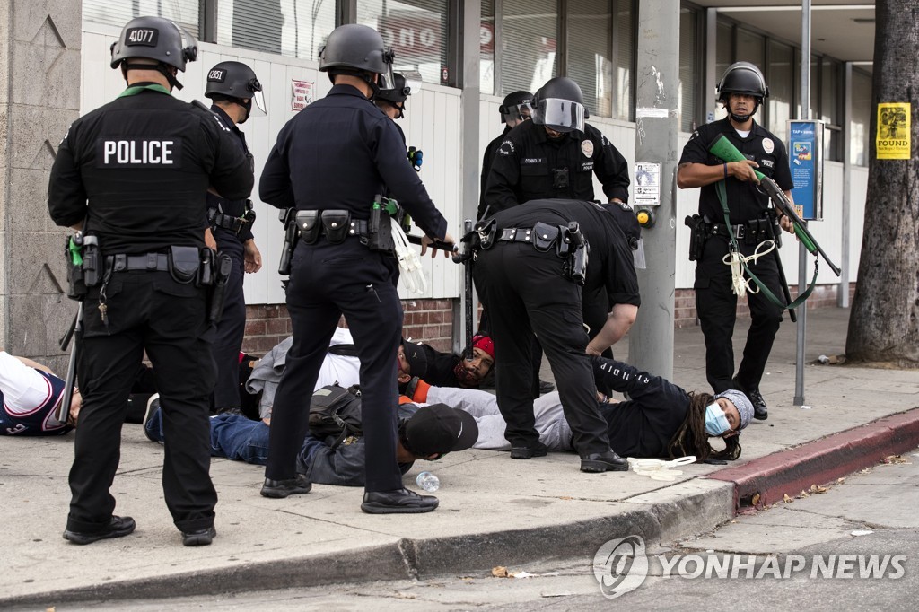 1일 미국 로스앤젤레스에서 통행금지 시작 후 경찰에 체포되는 시민들