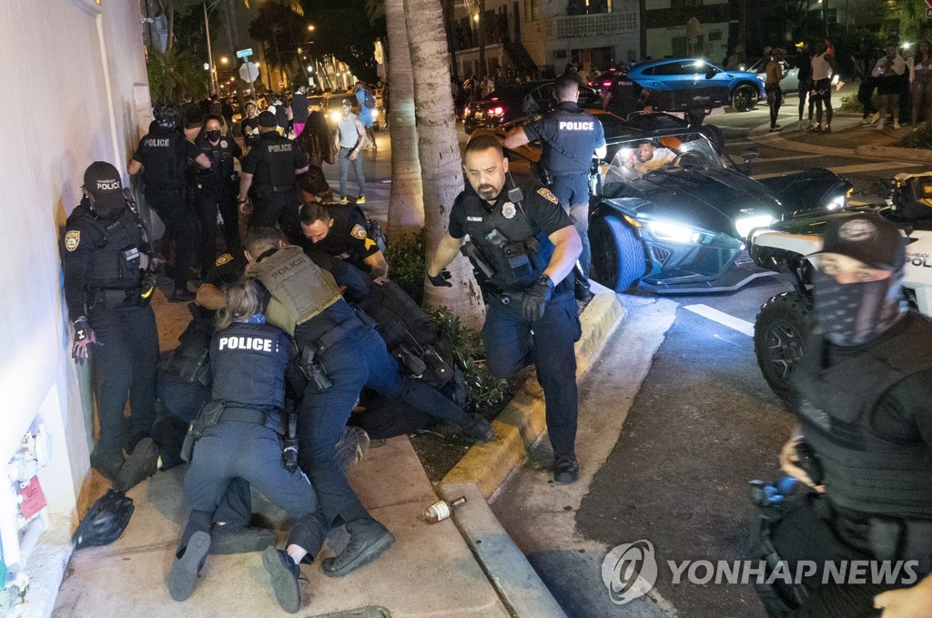 20일(현지시간) 저녁 미국 플로리다주 마이애미비치 경찰이 저녁 8시 통금을 어긴 사람들을 해산하고 있다.