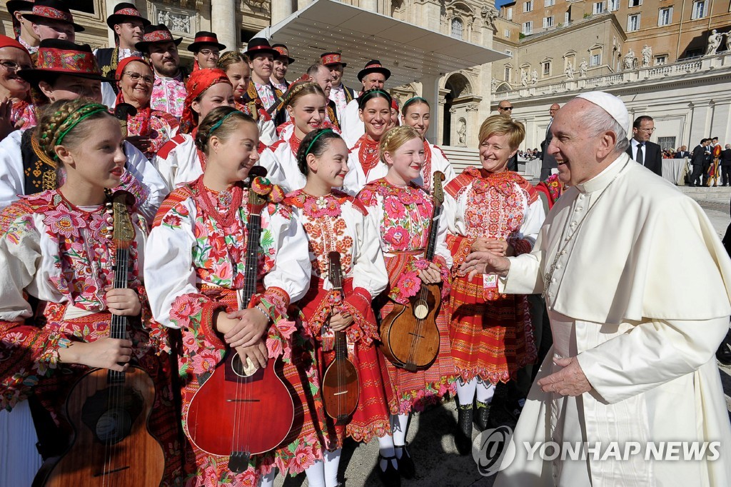 9일(현지시간) 바티칸 성베드로 광장에서 열린 수요 일반 알현에 참석한 크로아티아 소녀들과 반갑게 인사하는 프란치스코 교황. [로이터=연합뉴스]