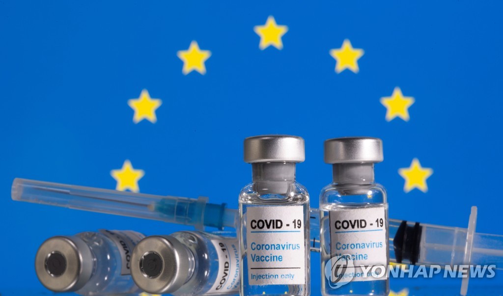 유럽연합(EU)기를 배경으로 신종 코로나바이러스 감염증(코로나19) 백신이라고 쓰여있는 약병이 놓여있는 이미지. [REUTERS/Dado Ruvic/Illustration=연합뉴스 자료사진]