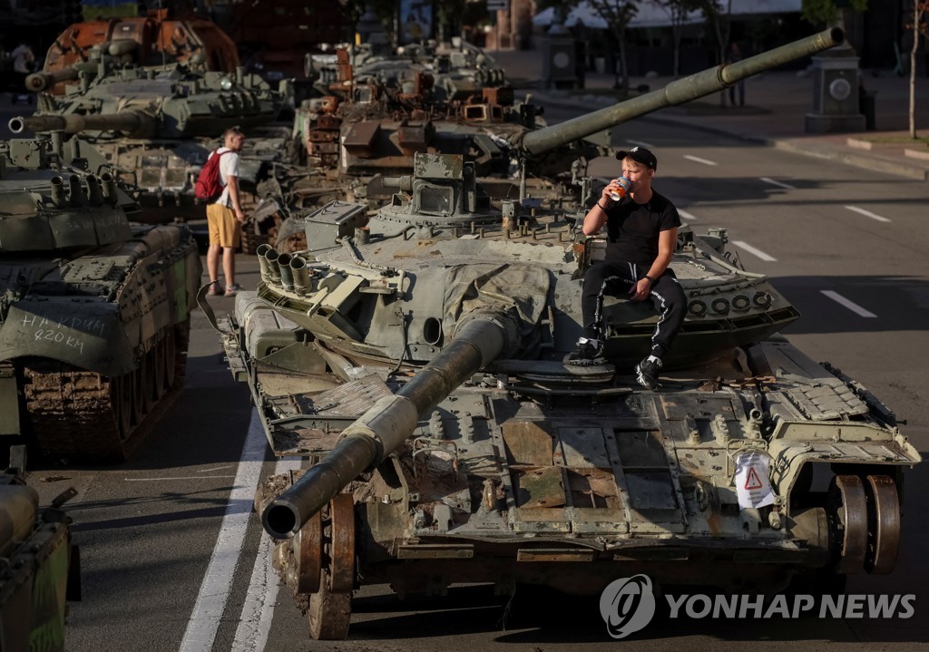 진열된 노획 러시아 전차에 앉아 커피마시는 우크라인