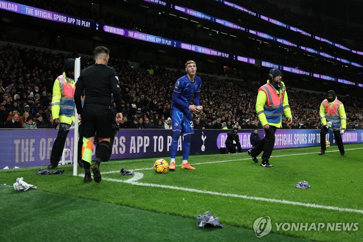 경기장으로 던져진 물건들을 치우는 관리 요원들