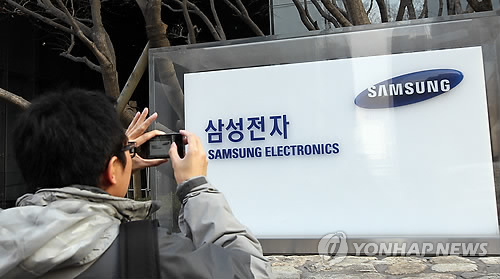 서울 서초동 삼성 사옥을 방문한 한 외국인이 건물 외부에 설치된 로고를 사진에 담고 있다.(자료사진)