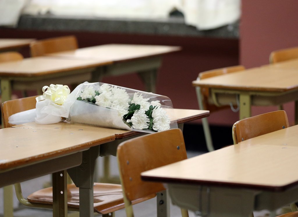 학교폭력으로 자살한 고교생의 장례식이 열린 지난 13일 급우들의 애도하는 마음이 담긴 꽃다발이 교실 책상 위에 놓여 있다.(자료사진)