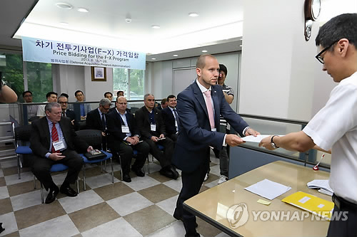 차기전투기사업(F-X) 가격입찰에 참가한 업체 관계자가 지난 18일 서울 후암동 방위사업청에서 보안서약서를 작성해 방위사업청 관계자에게 전달하고 있다.<<연합뉴스DB>>