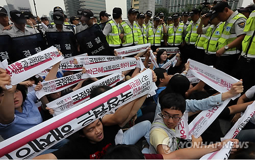 21세기 한국대학생연합 회원들이 지난 21일 서울 광화문광장 인근 도로 위에서 국정원 규탄 메시지가 담긴 손팻말을 들고 집회를 진행하고 있다. <<연합뉴스DB>>