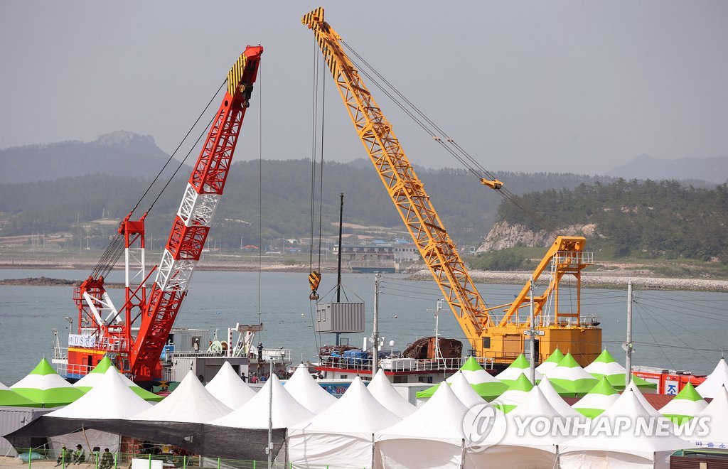 선체 절단 작업에 투입될 새 바지(화물운반선)는 예정보다 뒤늦게 사고해역에 도착했다. 사진은 28일 오후 전남 진도 팽목항에서 세월호 부분 절단 작업에 새롭게 참여할 팔팔 128호 바지(화물운반선)가 그동안 사고해역에서 수색 작업에 참가했던 DS-1 바지와 임무 교대를 위해 컨테이너를 옮겨 싣는 작업을 하는 모습.