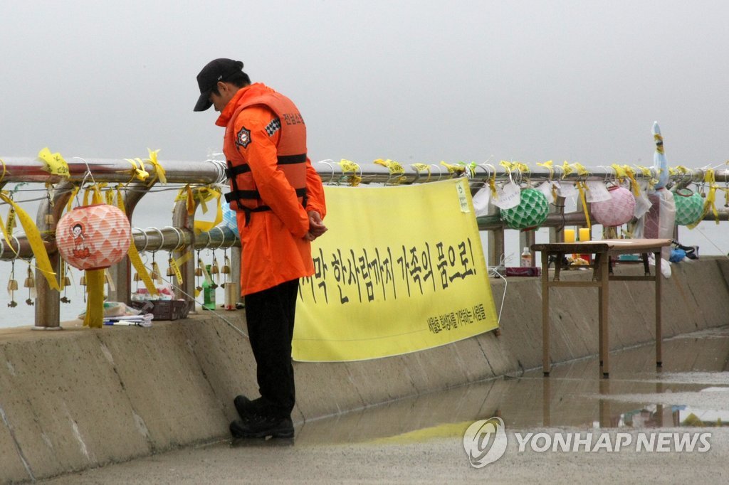 지난 3일 오후 팽목항 등대 앞에서 한 소방관이 바다를 바라보고 있다. 팽목항 곳곳에는 모든 실종자가 가족의 품으로 돌아갈 수 있는 플래 카드가 걸려 있다.