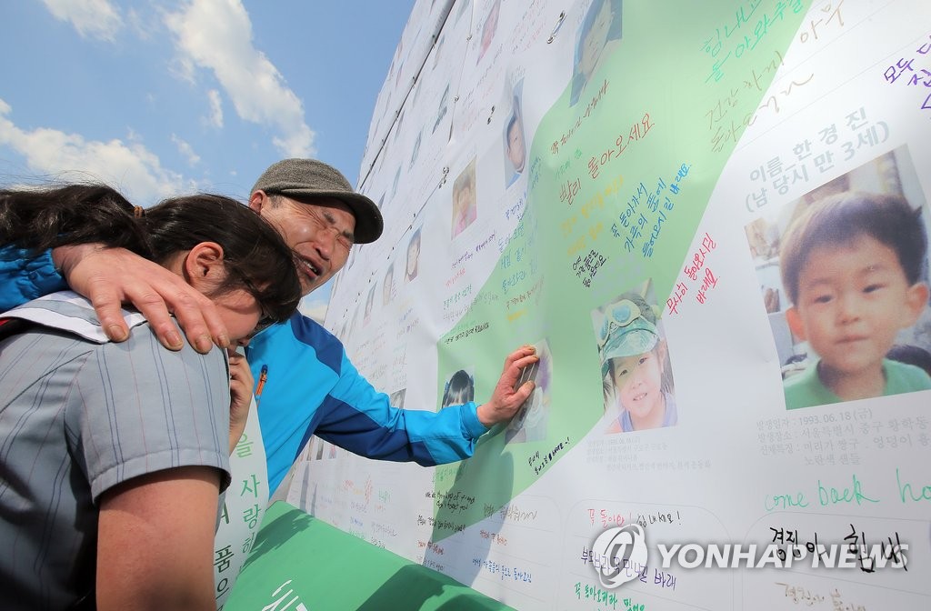 지난 20일 오후 서울 광화문광장에서 열린 9회 실종아동의 날 행사에서 박정문 씨가 실종된 아들 박진영 씨의 사진을 어루만지며 오열하고 있다.