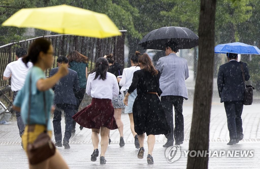 서울 영등포구 여의대로 근처에서 시민들이 내리는 비를 피하기 위해 발걸음을 재촉하고 있다.