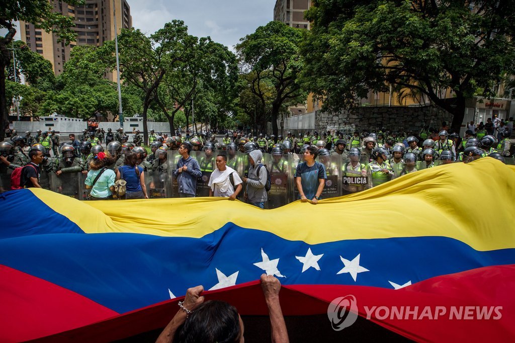 지난 5월 18일(현지시간) 베네수엘라 수도 카라카스에서 니콜라스 마두로 대통령 정부에 항의하며 베네수엘라 대형 국기를 들고 행진하고 있는 시위대
[EPA=연합뉴스 자료사진]