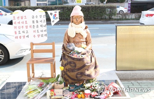 (부산=연합뉴스) 조정호 기자 = 9일 부산 동구 초량동 일본영사관 앞에 있는 평화의 소녀상 주변에 시민이 두고 간 꽃다발 등이 쌓여 있다. 한일 위안부 합의를 비판하는 글과 태극기도 보인다. 2017.1.9
ccho@yna.co.kr