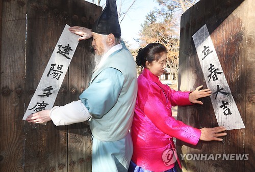'입춘대길' (용인=연합뉴스) 홍기원 기자 = 입춘을 이틀 앞둔 2일 경기도 용인시 한국민속촌 양반가 출입문에 민속촌 어르신들이 '입춘대길(立春大吉)'과 '건양다경(建陽多慶)'이라고 쓰인 입춘방(立春榜)을 붙이고 있다. 2017.2.2 xanadu@yna.co.kr