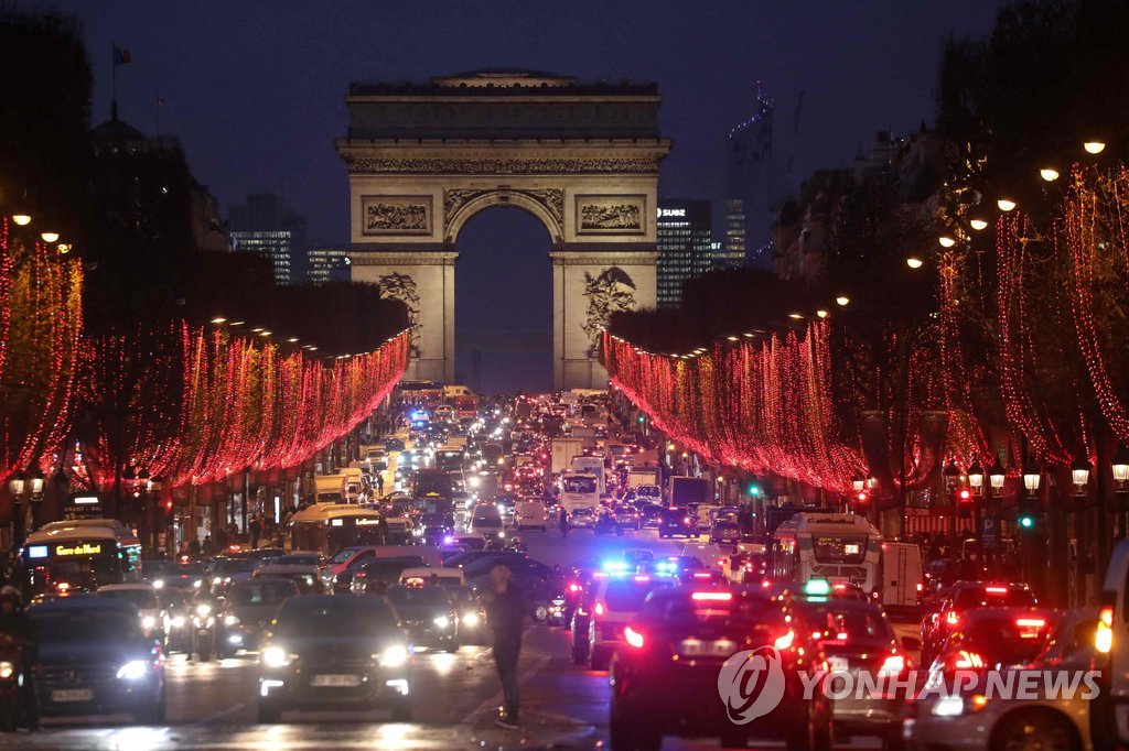 (파리 AFP=연합뉴스) 프랑스 '노란 조끼' 시위대의 전국적인 대규모 4차 집회를 하루 앞둔 지난 7일(현지시간) 저녁 파리 개선문 앞 샹젤리제 거리
