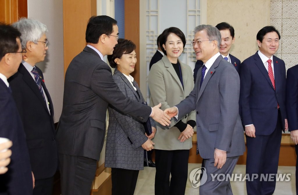 This photo, taken Jan. 8, 2019, shows President Moon Jae-in (R, front) shaking hands with Unification Minister Cho Myoung-gyon at a tea meeting ahead of a Cabinet meeting. (Yonhap)