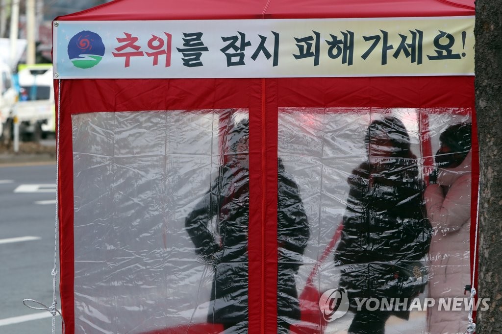 버스 정류장에서 추위 피하는 시민