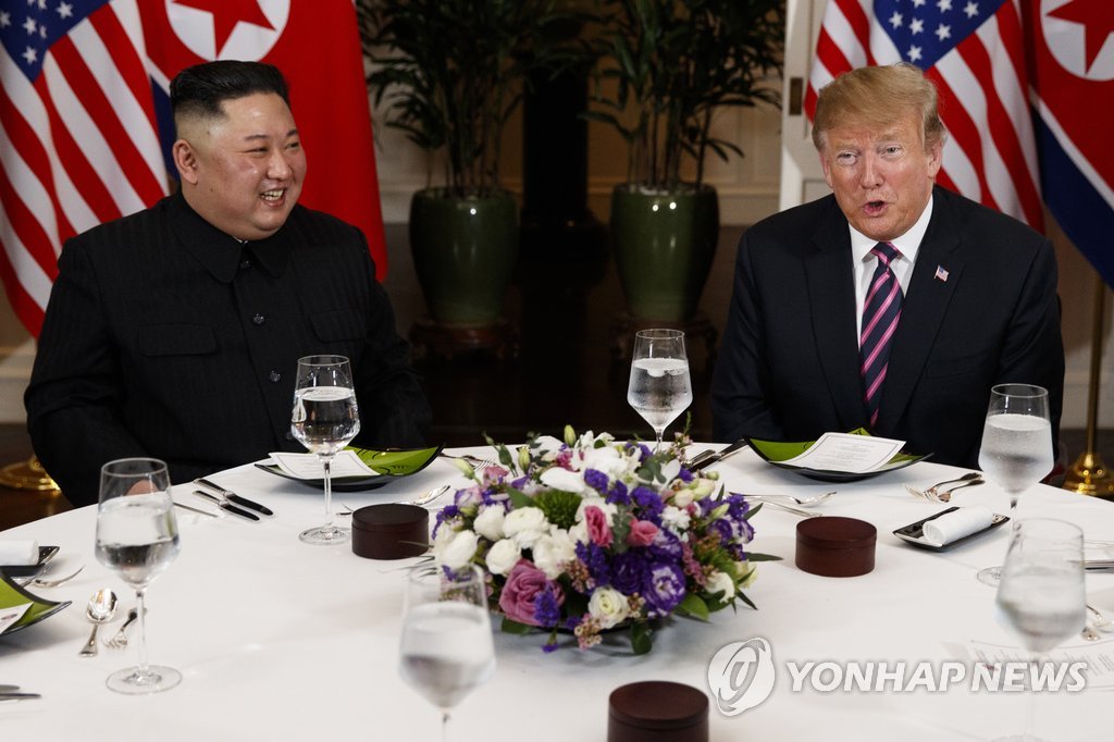 This photo, released by the Associated Press, shows U.S. President Donald Trump (R) speaking with North Korean leader Kim Jong-un during a dinner in Hanoi, Vietnam, on Feb. 27, 2019. (Yonhap)