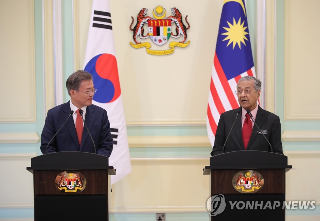 South Korean President Moon Jae-in (L) and Malaysian Prime Minister Mahathir Mohamad hold a joint press conference to announce the outcome of their summit in Putrajaya on March 13, 2019. (Yonhap)
