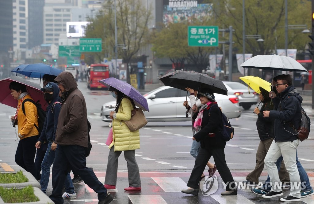 4월 14일 오전 비가 내리는 서울 광화문 거리에서 시민들이 발걸음을 재촉하고 있다. [연합뉴스 자료사진]