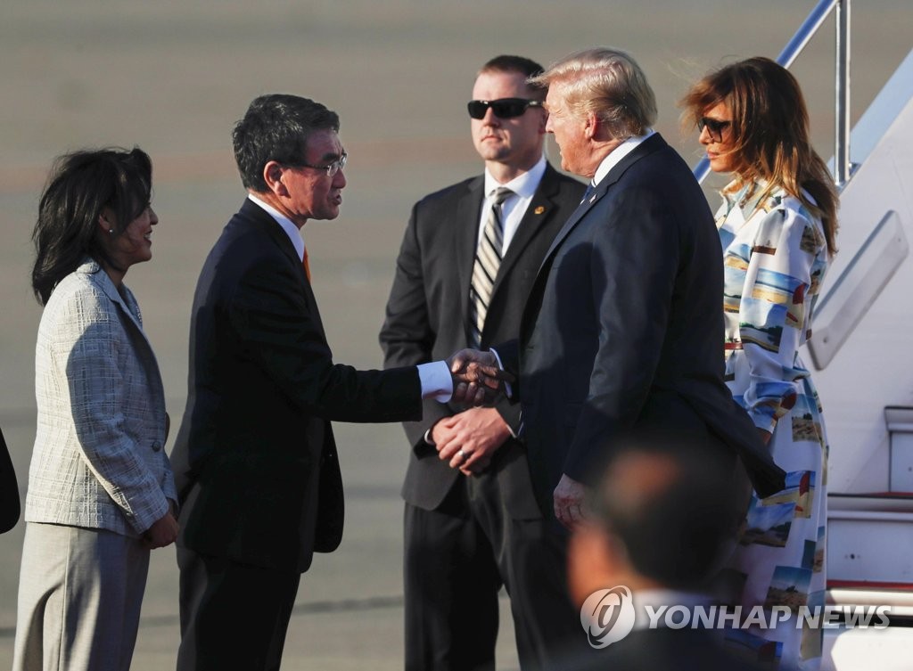25일 오후 도쿄 하네다공항에 전용기(에어포스원) 편으로 도착한 도널드 트럼프 미 대통령이 고노 다로 일본 외무상(왼쪽에서 2번째)의 영접을 받는 모습 [교도=연합뉴스 자료사진]