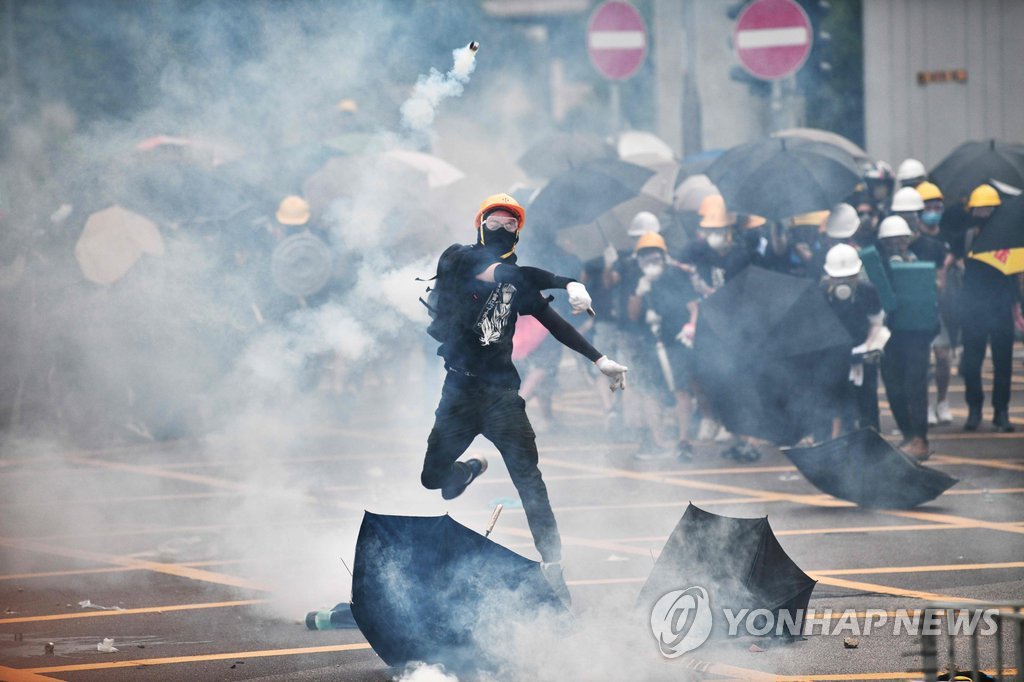 경찰이 쏜 최루탄 되던지는 홍콩 시위대