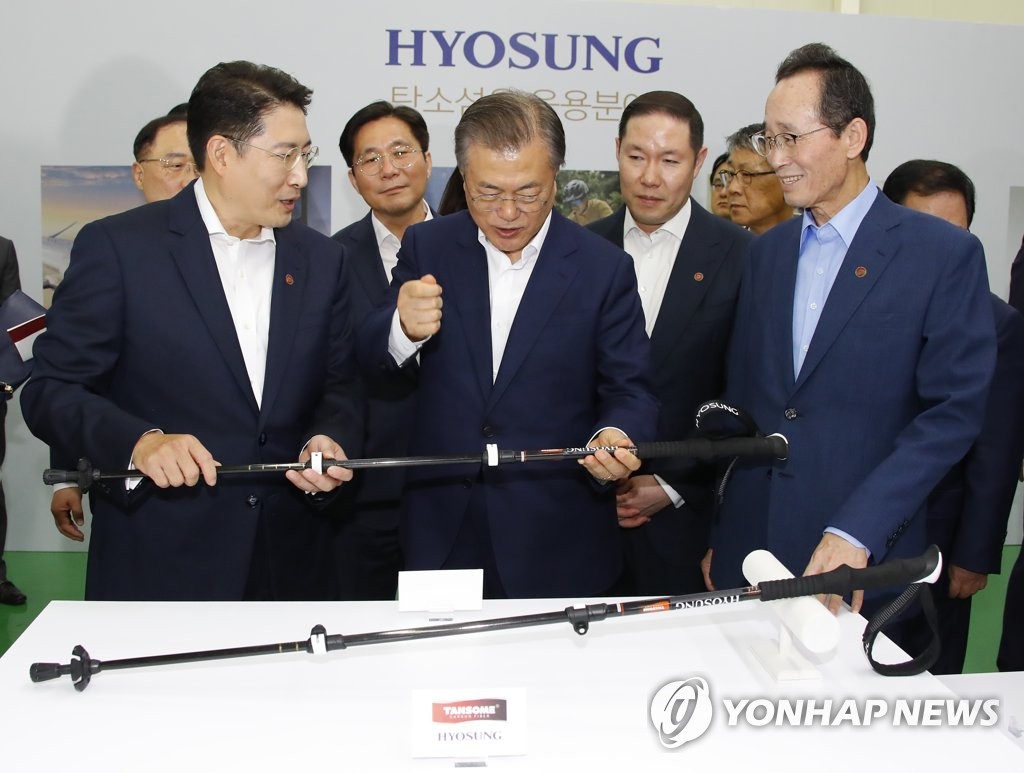 President Moon Jae-in (C) is briefed on a material using carbon fiber during an event on Hyosung Group's plan to sharply increase investment in its related business. It was held in Jeonju, North Jeolla Province, on Aug. 20, 2019. (Yonhap)