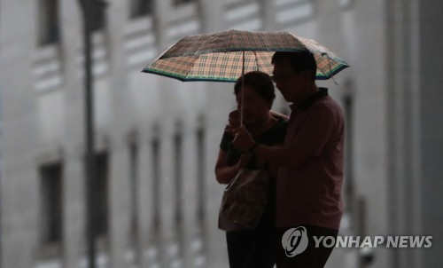 우산을 쓴 시민들이 발걸음을 옮기고 있는 모습.