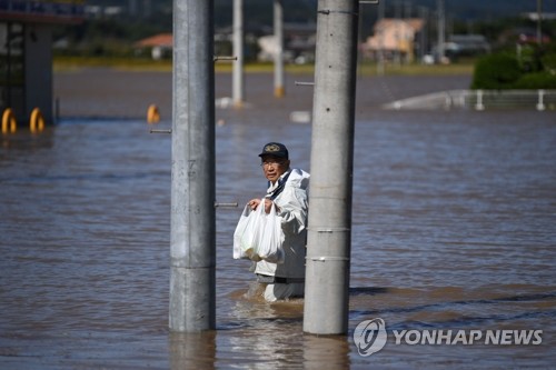 식료품 들고 침수지역 지나는 日 봉사자