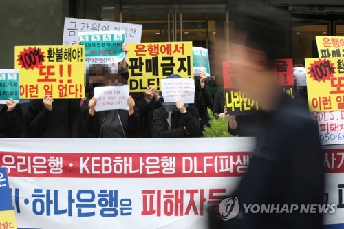 (서울=연합뉴스) 서명곤 기자 = 우리은행과 하나은행이 판매한 해외 금리 연계 파생결합펀드(DLF)로 투자금을 잃은 피해자들이 16일 오후 서울 중구 KEB하나은행 앞에서 열린 집회에서 '100% 환불' 등이 적힌 피켓을 들고 있다. 2019.10.16 seephoto@yna.co.kr