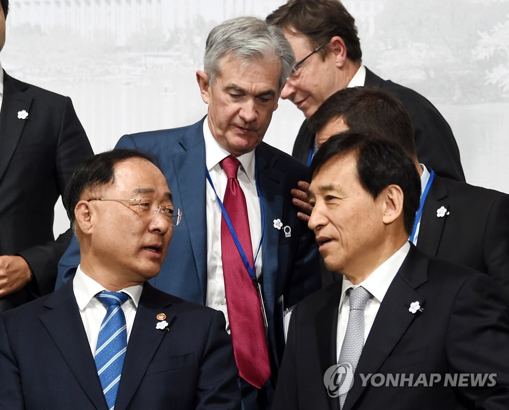 In the photo provided by the Finance Ministry, Bank of Korea Gov. Lee Ju-yeol (R) and South Korean Finance Minister Hong Nam-ki (L) are seen posing for a group photo at the Group of 20 Finance Ministers and Central Bank Governors' Meeting in Washington on Oct. 17, 2019. (PHOTO NOT FOR SALE) (Yonhap)