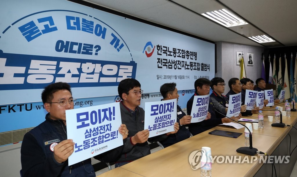 Participants at a ceremony marking the launch of a labor union of Samsung Electronics Co. under one of South Korea's two largest umbrella labor unions hold up signs with slogans in Seoul on Nov. 16, 2019. (Yonhap)