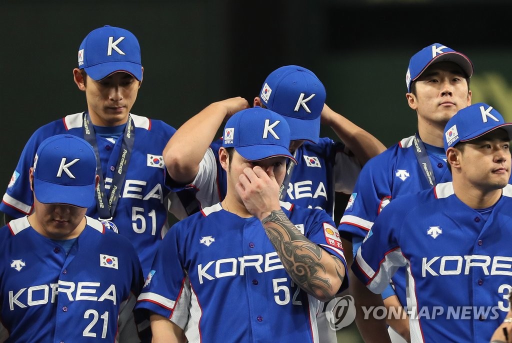 Park Byung-ho of South Korea (C, first row) wipes away tears during the medal ceremony of the World Baseball Softball Confederation (WBSC) Premier12 at Tokyo Dome in Tokyo on Nov. 17, 2019, following South Korea's 5-3 loss to Japan in the final. (Yonhap)
