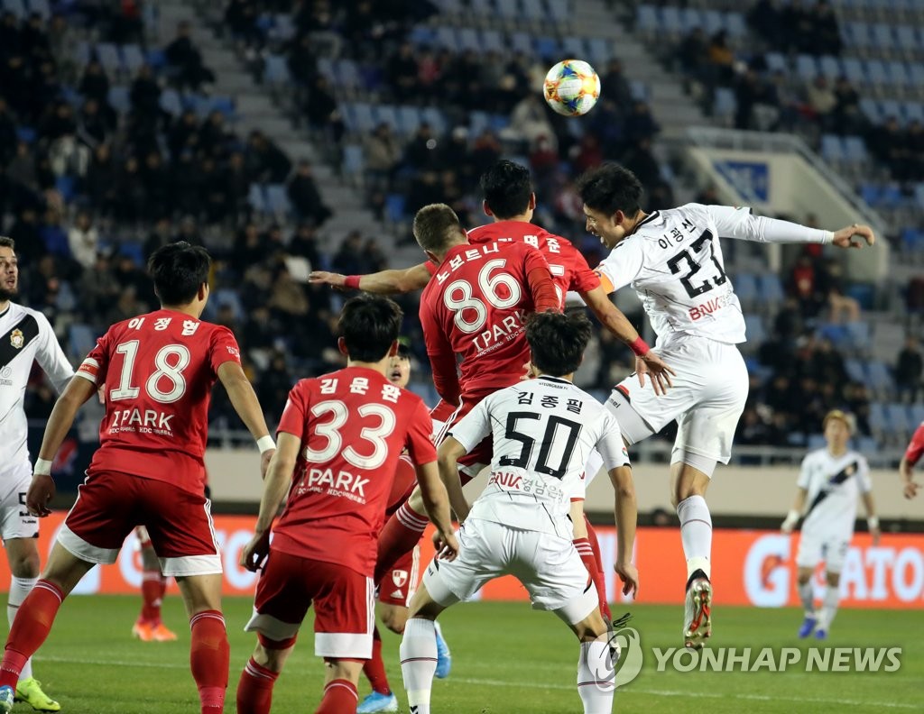 Lee Kwang-seon of Gyeongnam FC (R) tries to head the ball during a K League promotion-relegation playoff match against Busan IPark at Busan Gudeok Stadium in Busan, 450 kilometers southeast of Seoul, on Dec. 5, 2019. (Yonhap)