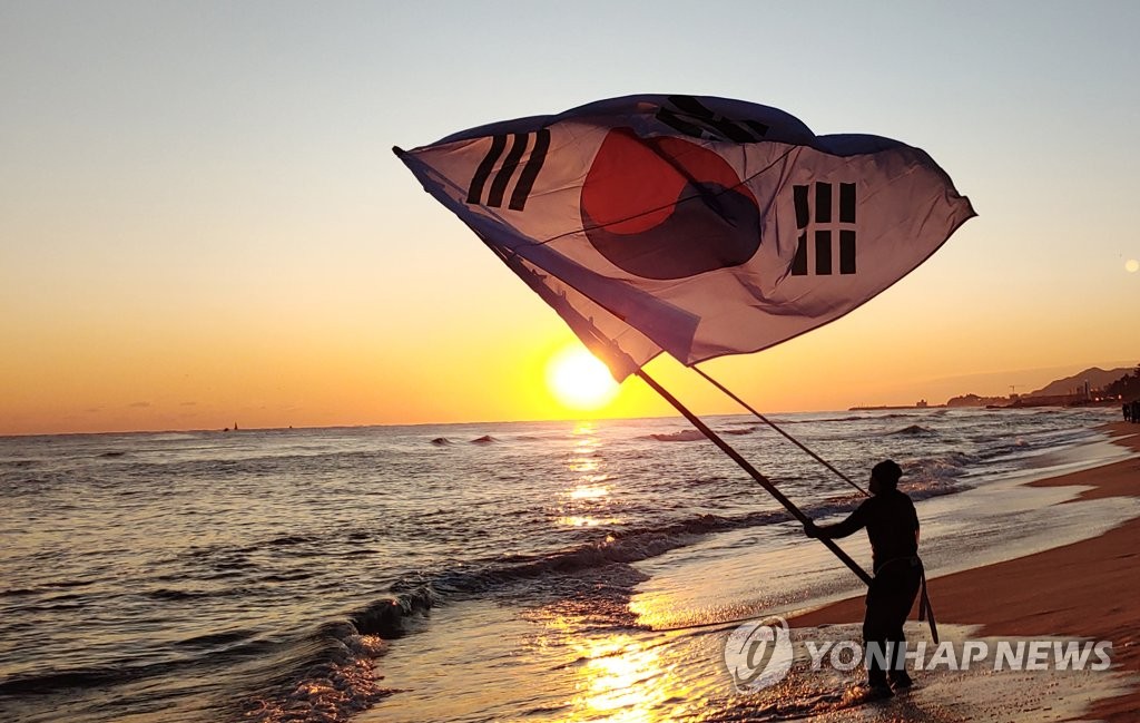 새해 일출 위로 휘날리는 태극기