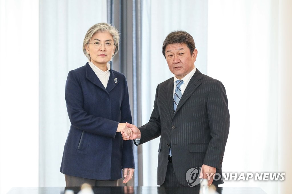 Foreign Minister Kang Kyung-wha (L) shakes hands with her Japanese counterpart, Toshimitsu Motegi, before their talks on the sidelines of an international security forum in Munich, Germany, on Feb. 15, 2020, in this photo provided by Kang's office. (PHOTO NOT FOR SALE) (Yonhap)