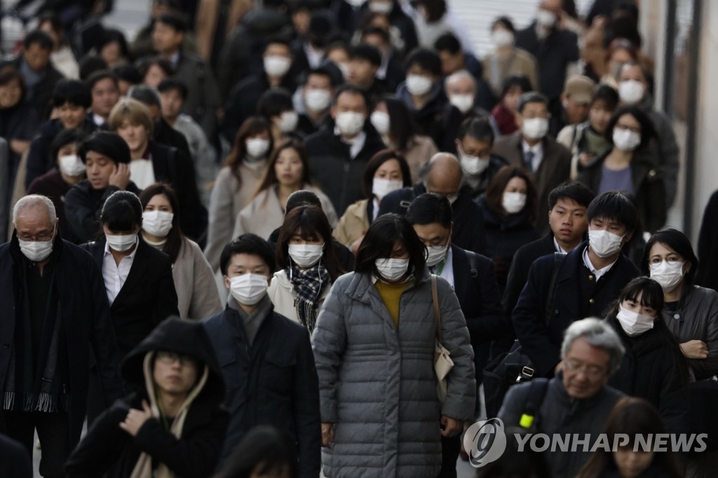 (도쿄 AP=연합뉴스) 중국발 신종 코로나바이러스(코로나 19)의 충격이 확대되고 있는 가운데 18일 일본 도쿄의 직장인들이 대거 마스크를 착용하고 인도를 걸어가고 있다. 